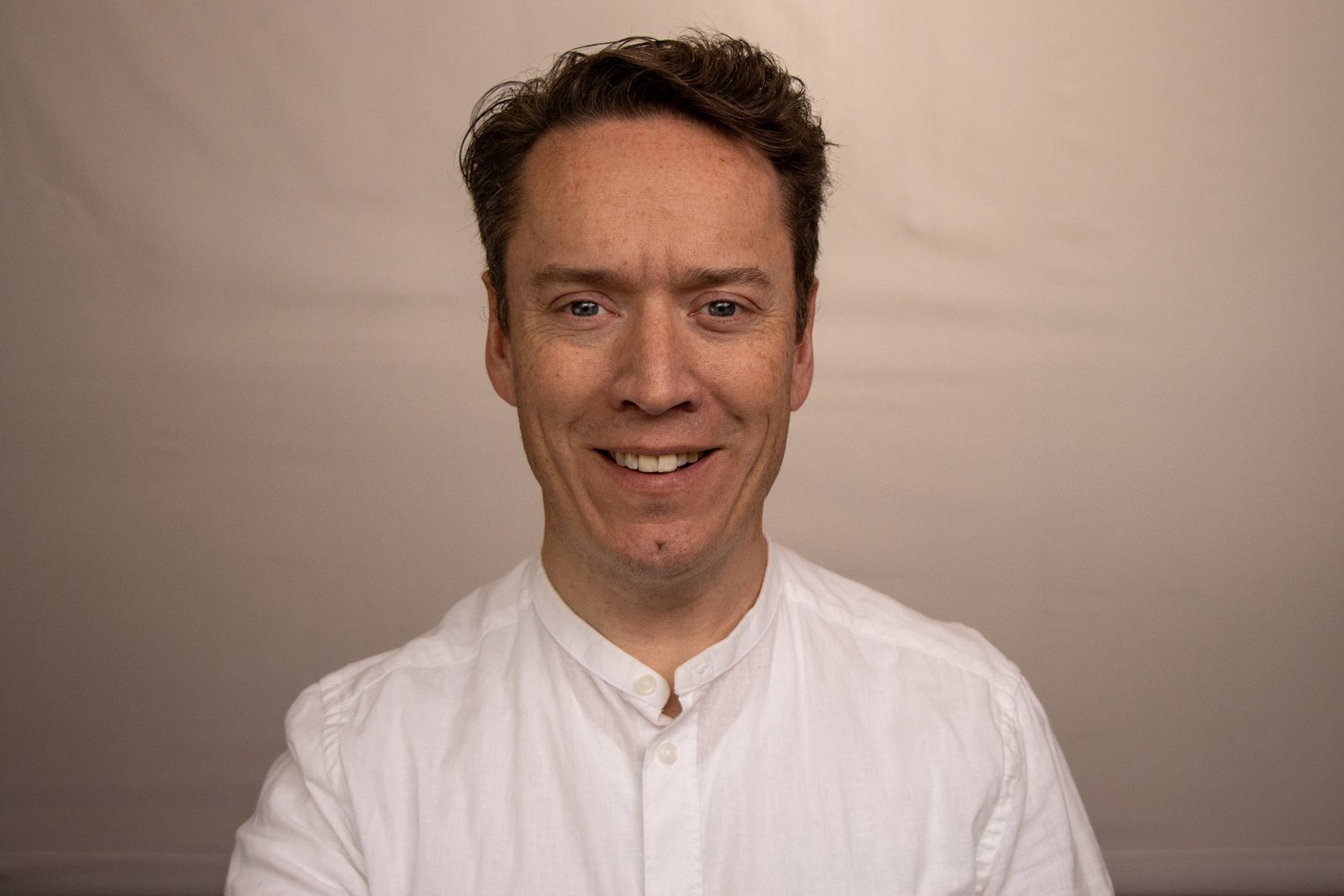 Greg Simpson smiling in a white shirt